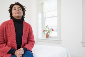 Woman enjoying fresh, clean indoor air in a bright, airy room.