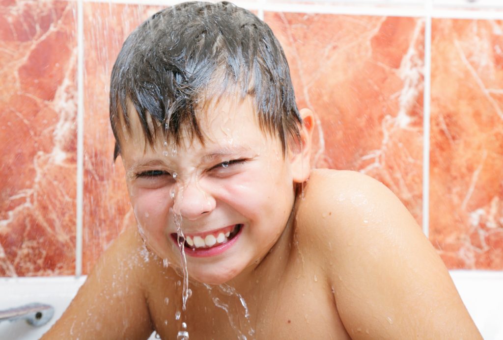 Boy enjoying a warm bath with a water heater