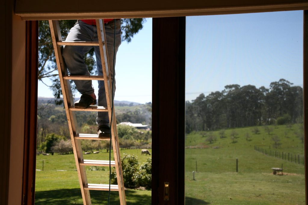 Man climbing a ladder following ladder safety tips