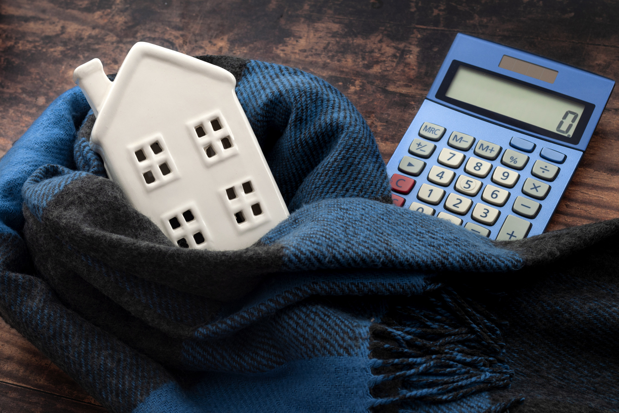 House wrapped in a wool scarf with calculator for heating cost efficiency