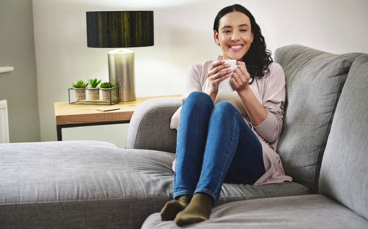 Girl sitting in an AC system room, looking relaxed and cool while enjoying the air conditioning.