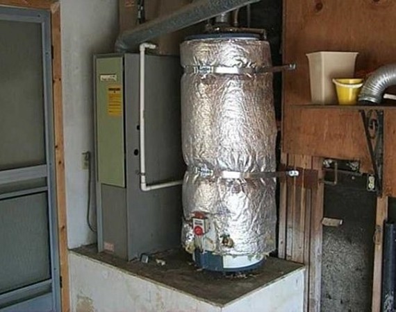 Insulating a home water heater with an insulation blanket to prevent heat loss during winter