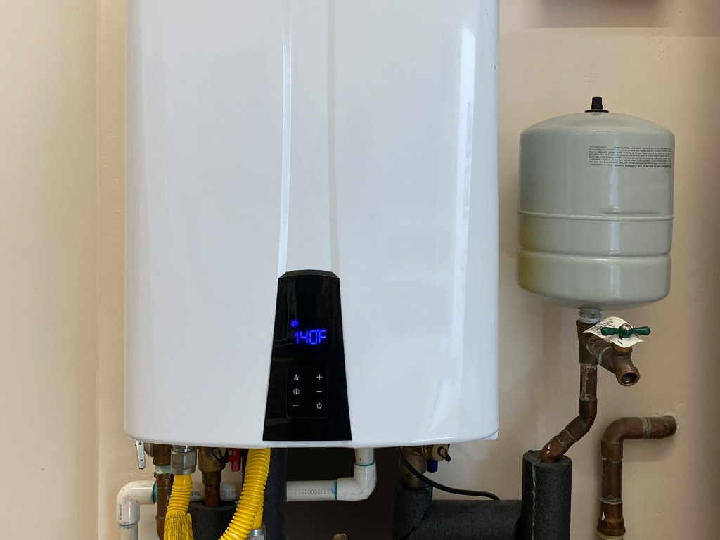 Tankless water heater turned on displaying digital temperature and performance readings